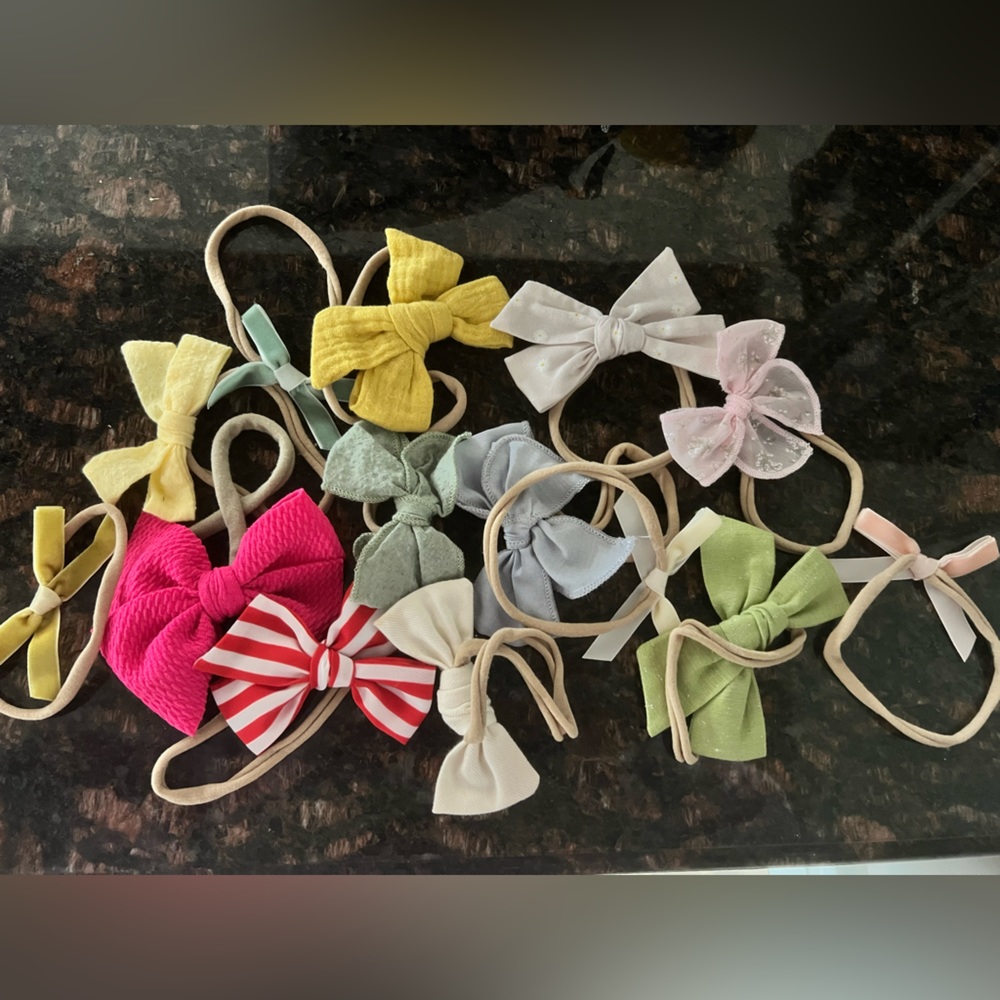 Assortment of baby bows, some unworn and some worn a handful of times.